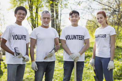 four volunteers standing and holding garden tools