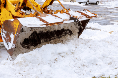 excavator for snow removal on a snowy parking lot after blizzard